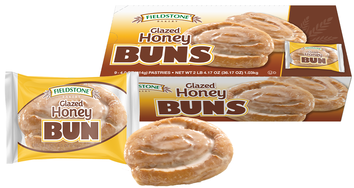 A yellow and white package with a glazed honey bun pastry showing through the clear cellophane in the middle of the packaging. Two unwrapped honey buns are pictured behind the package. A carton of honey buns is in the background.