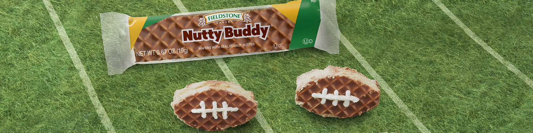 Nutty Buddy bars cut and iced to look like small footballs sit on a fake football field background.